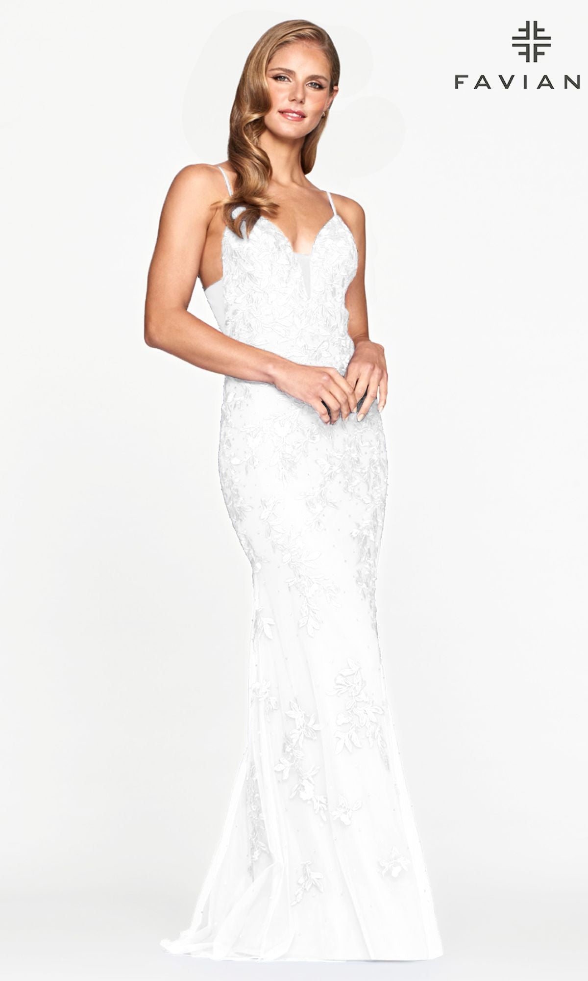 A woman in the Sheer-Sides Long Lace Prom Dress by Faviana, a fitted white gown with thin straps, stands against a plain white background. The